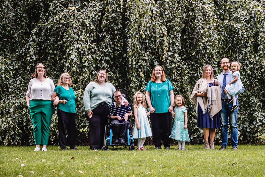 Families - family of 11 standing together in front of large tree