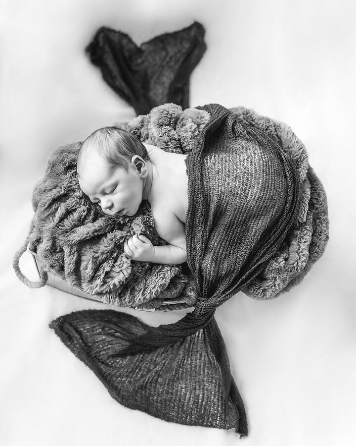 Baby - top down view of newborn sleeping on tummy, with blanket spread around them