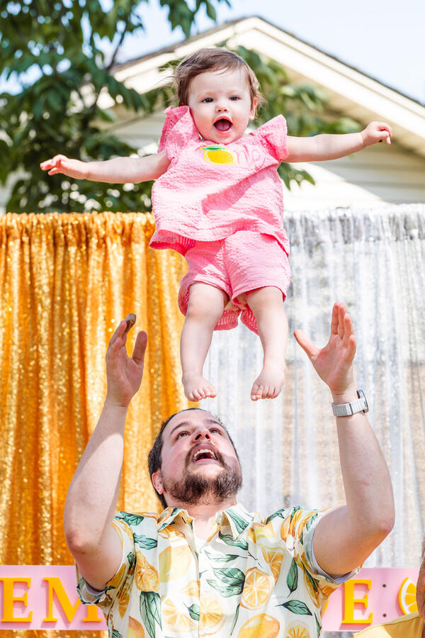 Baby - 1 year old smiling as she's tossed into air by dad