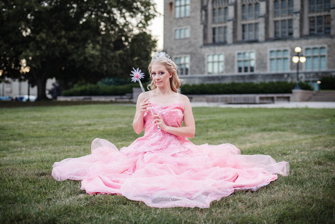 Styled Shoot - Glinda cosplay sitting in grassy field, holding wand