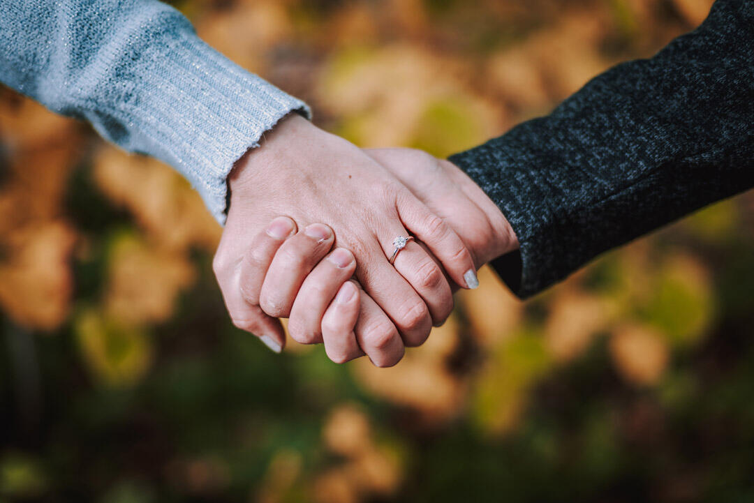 Couple - holding hands to show off engagement ring
