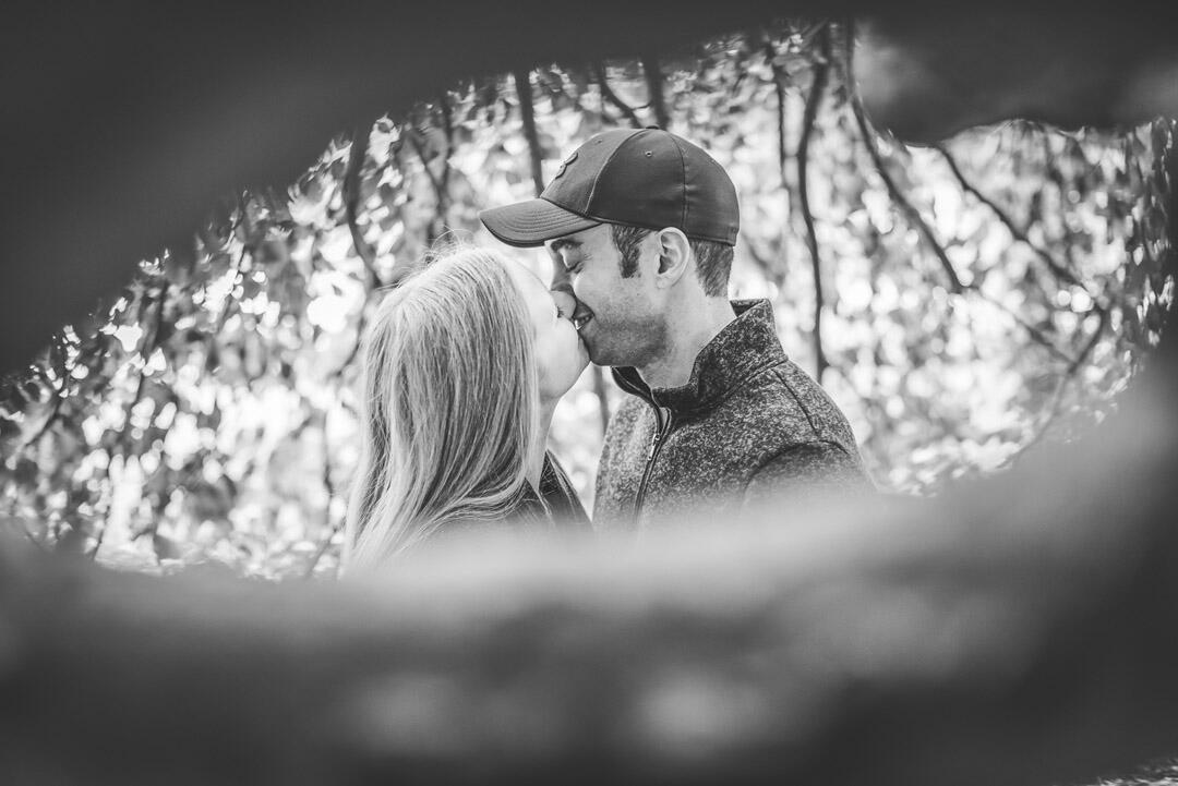 Couple - kissing; looking through a hole in a tree