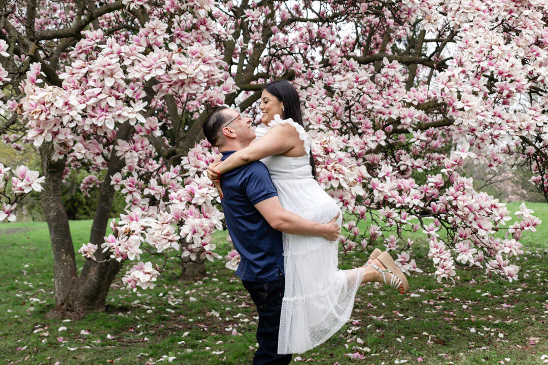 Couple - man lifting woman in front of a blossom tree